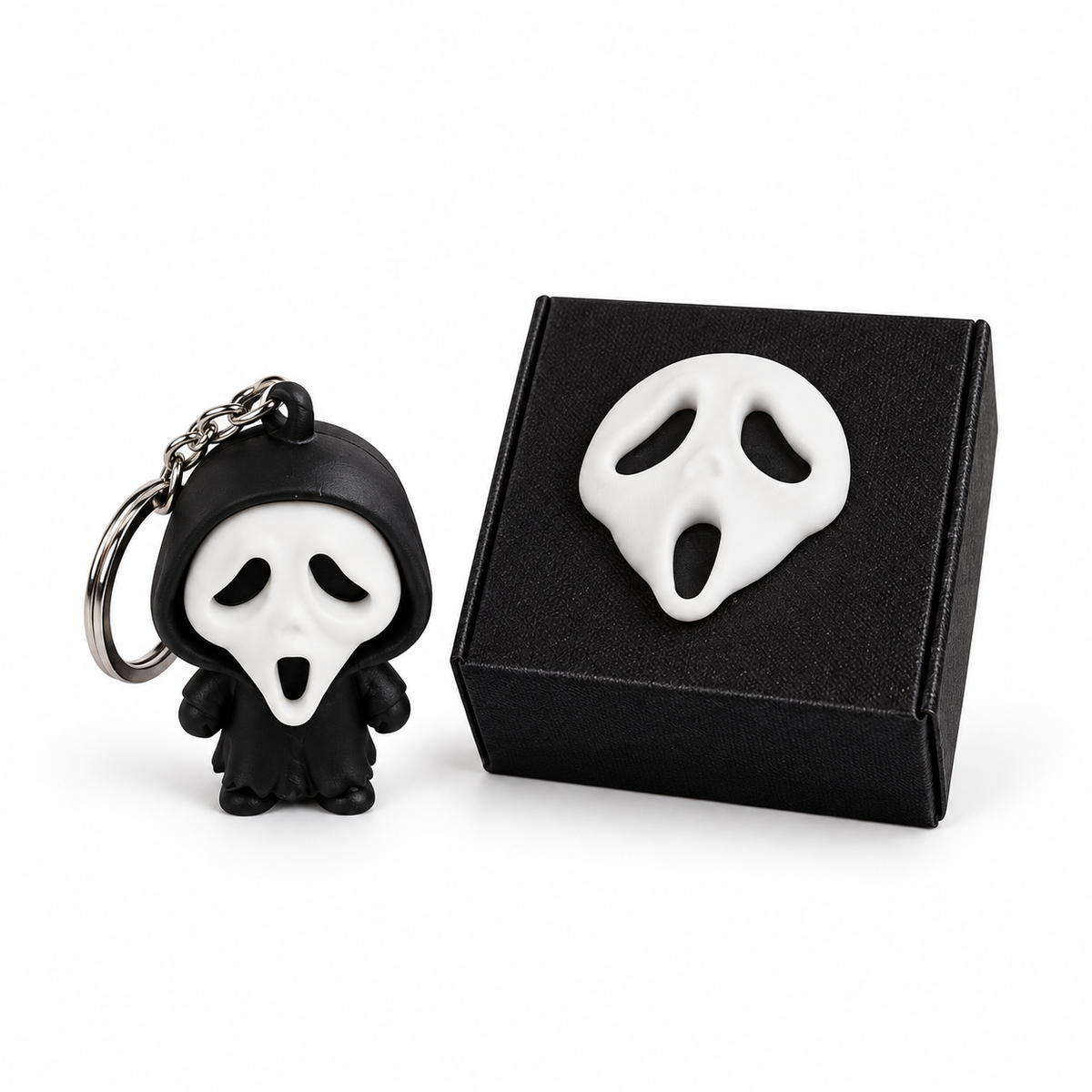 Ghost-face character keychain beside its matching black personalised gift box