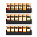 Three black spice organisers displayed with six spice jars each on a white background